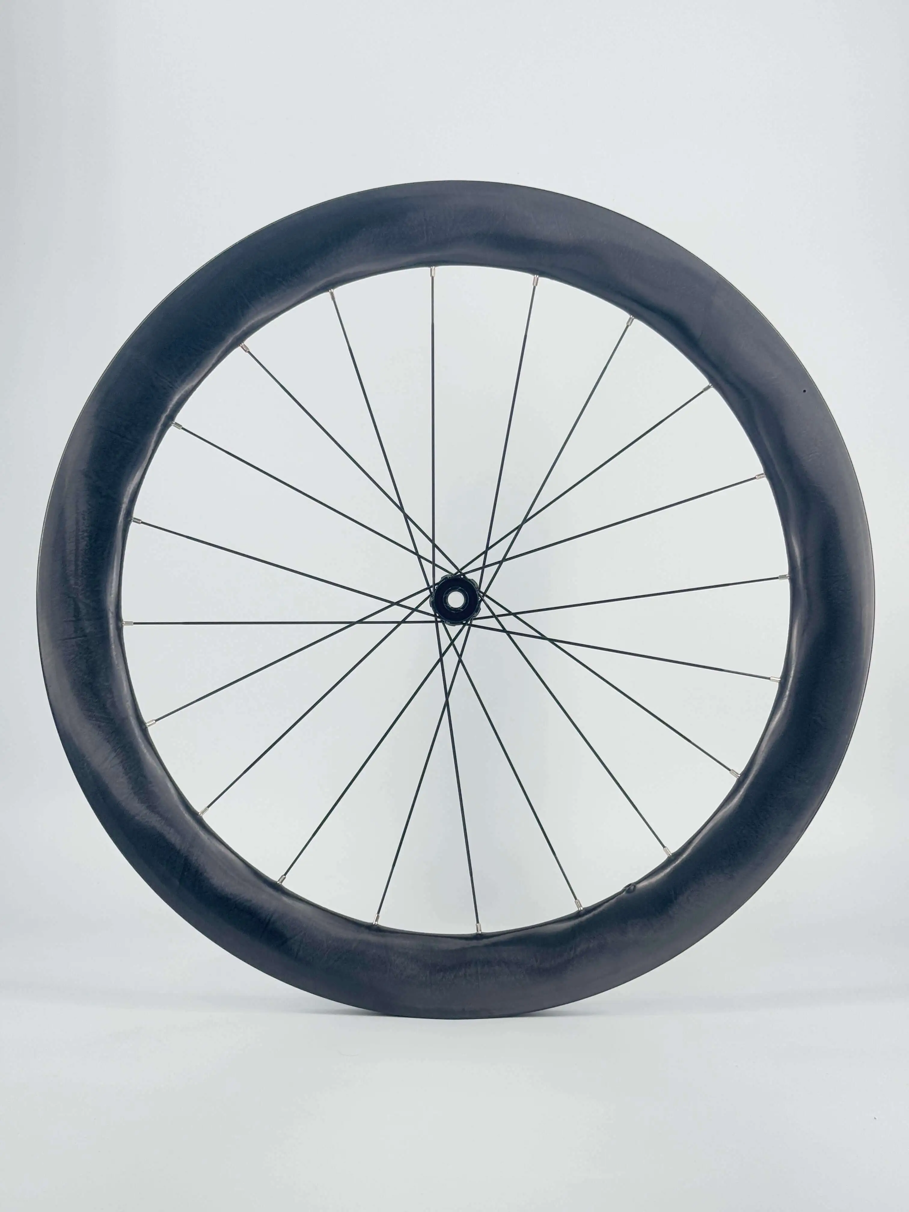 Deep-section carbon wheel with crossed bladed spokes and silver nipples, hand-built by Light Travel Cycling for an OEM program