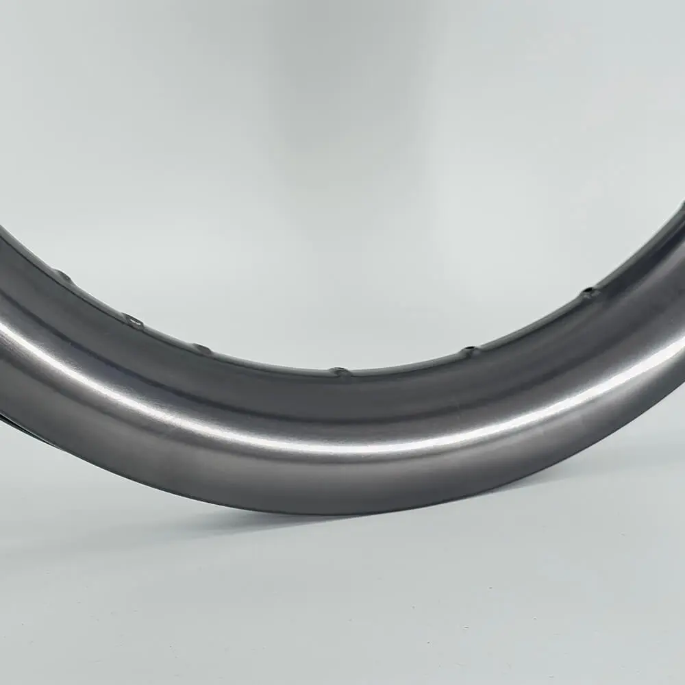 Glossy black carbon rim arc with mirror highlight, showing finish quality of OEM rims developed by Light Travel Cycling