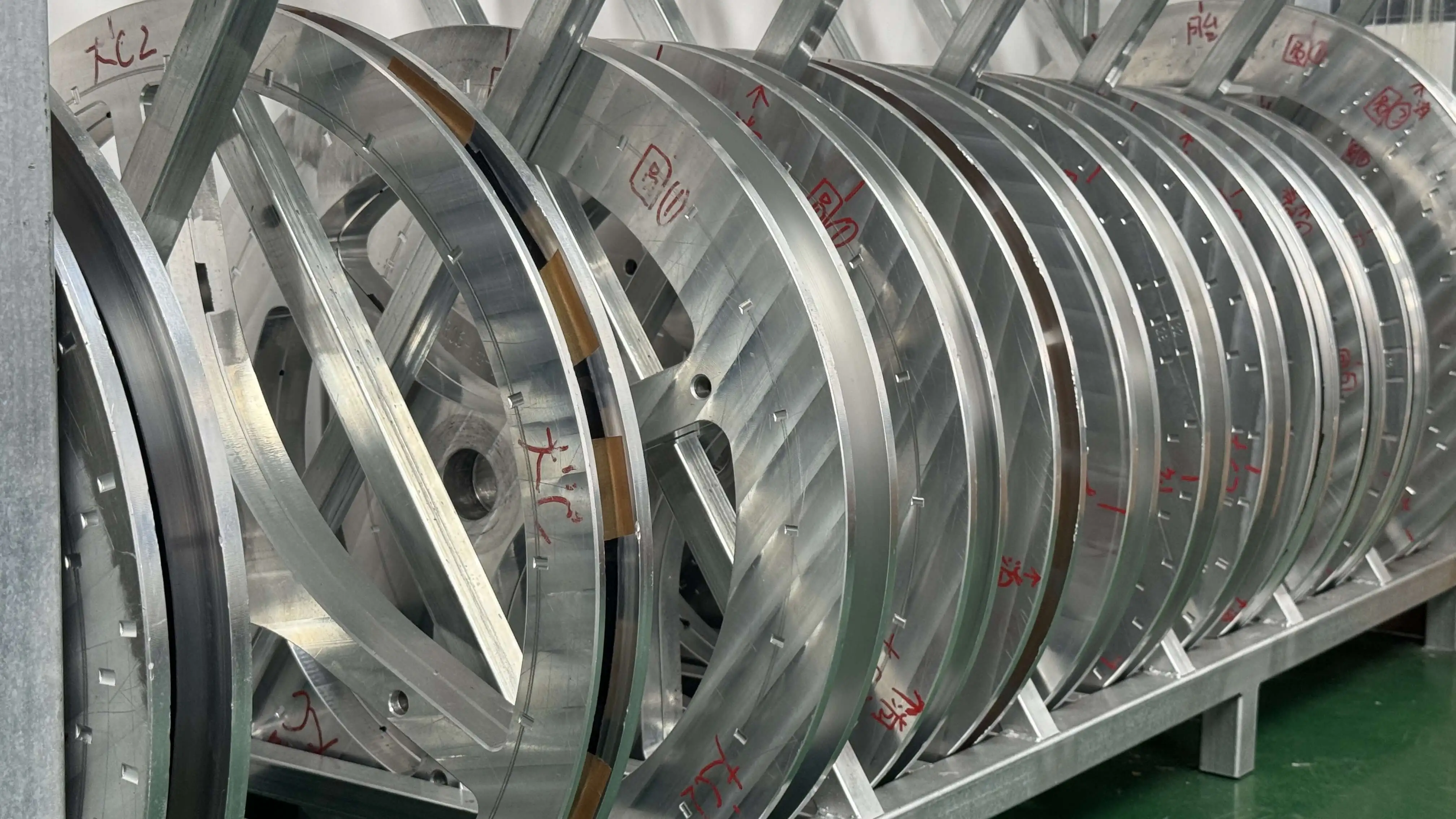 CNC steel rim molds stored on a labeled rack at the Light Travel Cycling factory, each mold tagged for a customer-owned tooling project